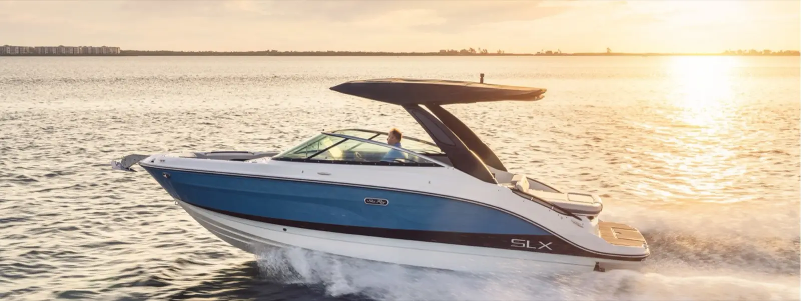 Sea Ray SLX cruising at golden hour on Beaver Lake